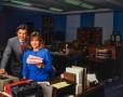 Photograph: [Photograph of Jane McGarry and a man at a desk in an office]
