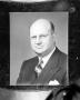 Photograph: [An unknown man wearing a suit and glasses]