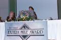 Photograph: [Susan Gore at Extra Mile Award podium]
