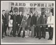 Primary view of [Photograph of a group of people cutting a Grand Opening ribbon]