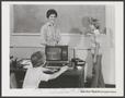 Photograph: [Advertisement of a classroom scene around a computer]