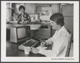 Photograph: [Advertisement with a man sitting at a table with a TRS-80 computer i…