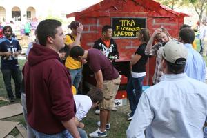 Primary view of object titled '[Students converse in front of Pi Kappa Alpha cardboard house at Shack-a-thon fundraising event]'.