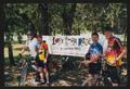 Photograph: [Four cyclists posing by an LSR banner, 2: Lone Star Ride 2003 event …