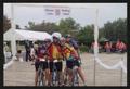 Photograph: [Five cyclists posed hugging under a constructed archway: Lone Star R…