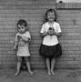 Photograph: [Two children standing in front of a brick wall #2]