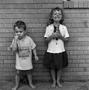 Photograph: [Two children standing in front of a brick wall #4]
