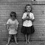 Photograph: [Two children standing in front of a brick wall #8]