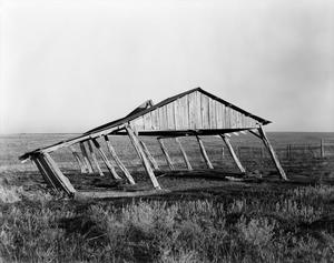 Primary view of object titled '[Photograph of the leaning frame of a barn]'.