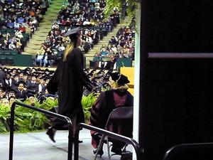 Primary view of object titled '[Master's graduate walks stage during UNT Fall 2007 Commencement]'.