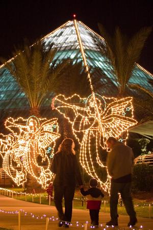 Primary view of object titled '[Family 2 walks through Galveston Festival of Lights angel display]'.