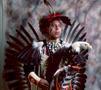 Photograph: [An Indigenous American in traditional black and red powwow clothing]