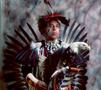 Photograph: [An Indigenous American in traditional black and red powwow clothing,…