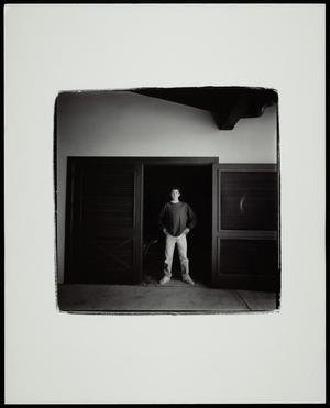 Primary view of object titled '[Young man standing in a doorway]'.