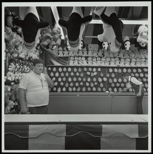 Primary view of object titled '[Two people working a balloon dart carnival game]'.