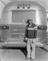 Photograph: [A man standing in front of the rear of an airstream]