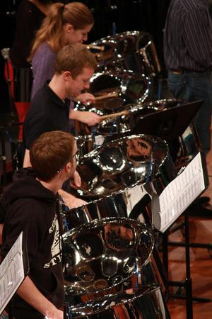 Primary view of object titled '[A row of people playing drums in front of music stands]'.