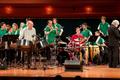Photograph: [Rows of percussionists in green shirts performing onstage, 3]