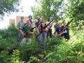Photograph: [Nine people holding bassoons while standing in foliage]
