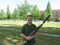 Photograph: [A man in a green shirt posing with a bassoon, 1]