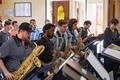 Photograph: [A row of men playing saxophones in a crowded room]