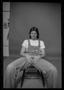 Photograph: [Man in Overalls Sitting in a Studio]