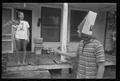 Photograph: [Man with a bag on his head talking to a woman behind him]