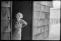 Primary view of [Elderly woman standing in a doorway]