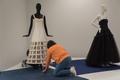 Primary view of [Janelle McCabe and Annette Becker placing a wedding dress on mannequin]