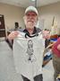 Photograph: [Steve Brooks holding up t-shirt of his design of Willie Nelson, 2]