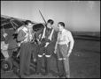 Photograph: [Three Men Donning Flight Equipment]