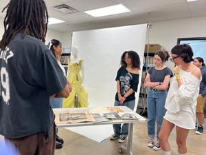 Primary view of [Students reviewing materials relating to a 1950s Lilli Wolff debutante dress]