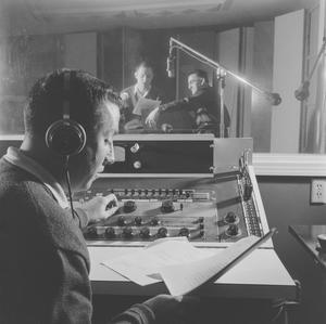 Primary view of object titled '[A man with paper beside recording equipment, 3]'.
