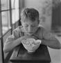 Photograph: [A boy looking down at a bowl, 2]