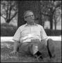 Thumbnail image of item number 1 in: '[Dr. Wayne Adams lounges beneath a tree]'.