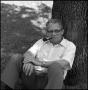 Primary view of [Dr. Wayne Adams  sits beneath a tree]
