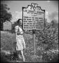 Photograph: [Bernice posing with the Lee County sign]