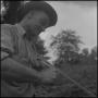 Photograph: [Photograph of a man splitting wood into strips, 1]