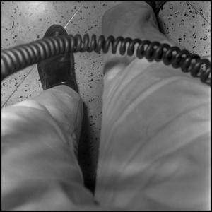 Primary view of [Photograph of a pair of legs and a telephone cord]