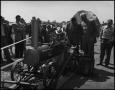 Photograph: [Men looking at an engine on wheels]