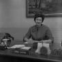 Photograph: [Dr. Irma Canton sitting behind her desk, 5]