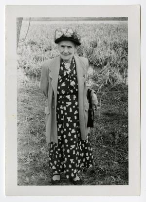 Primary view of object titled '[Adelaida Cuellar standing in front of a field]'.