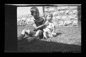Primary view of object titled '[John Williams sitting in the grass with his brother Charles]'.