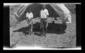 Photograph: [Byrd Williams III standing under a tent with his brother John]