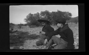 Primary view of object titled '[Byrd Williams III and John Williams sitting outside]'.
