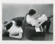 Photograph: [Two male students reading materials in library]