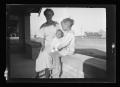 Photograph: [Irene Williams and her sons sitting on a porch]