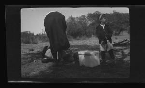 Primary view of object titled '[Irene Williams and Charles Williams cooking outside]'.
