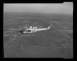 Photograph: [XH-40 number 3 in first flight over Hurst plant]