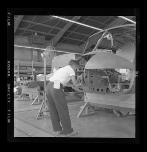 Primary view of object titled '[Bell employee working on the nose assembly of the XH-40]'.
